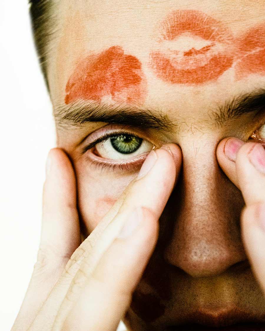 Un homme avec des traces de rouge à lèvre sur son front