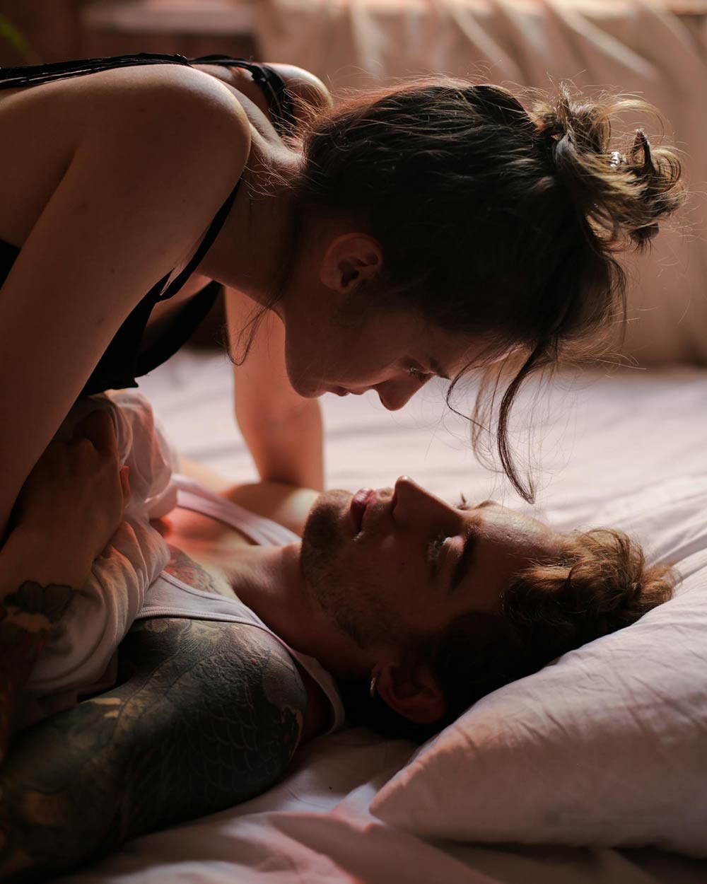 Un couple sur un lit se regardant
