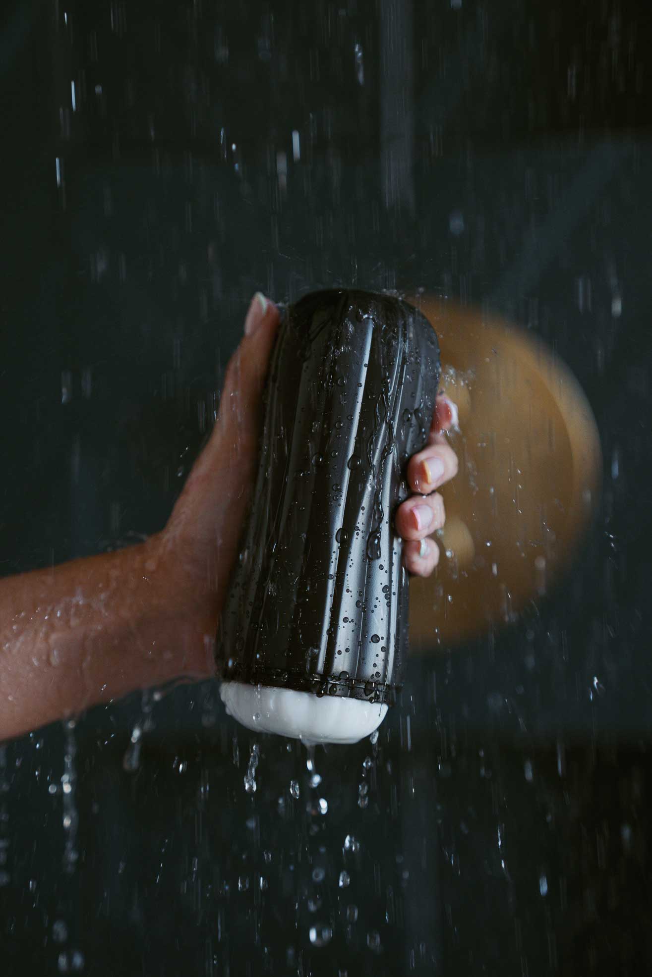 Une main tenant ONY Pure 2 dans la douche